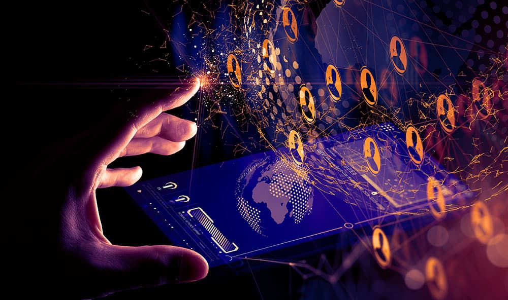 Hand berührt virtuelle Netzwerk-Struktur, in der Personen-Symbole eingebunden sind. Darunter liegt ein Smartphone.