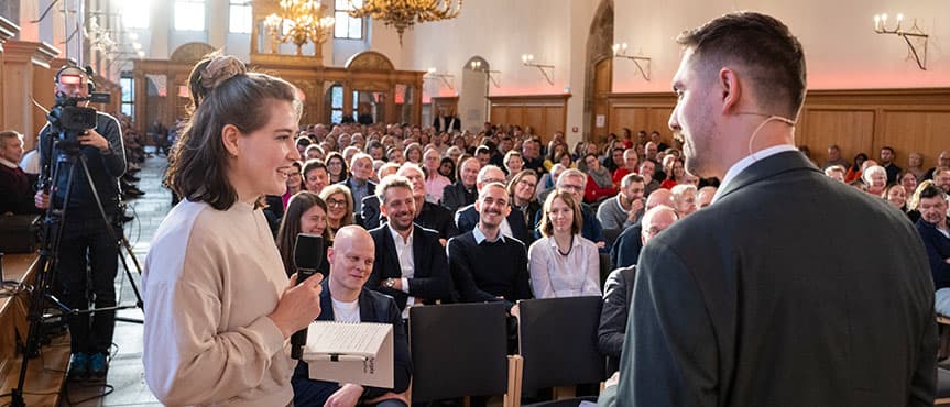 Nina Heinicke, Studentin der Sozialökonomik an der Friedrich-Alexander-Universität Erlangen-Nürnberg im Gespräch mit dem Moderator bei den Nürnberger Gesprächen 2026.