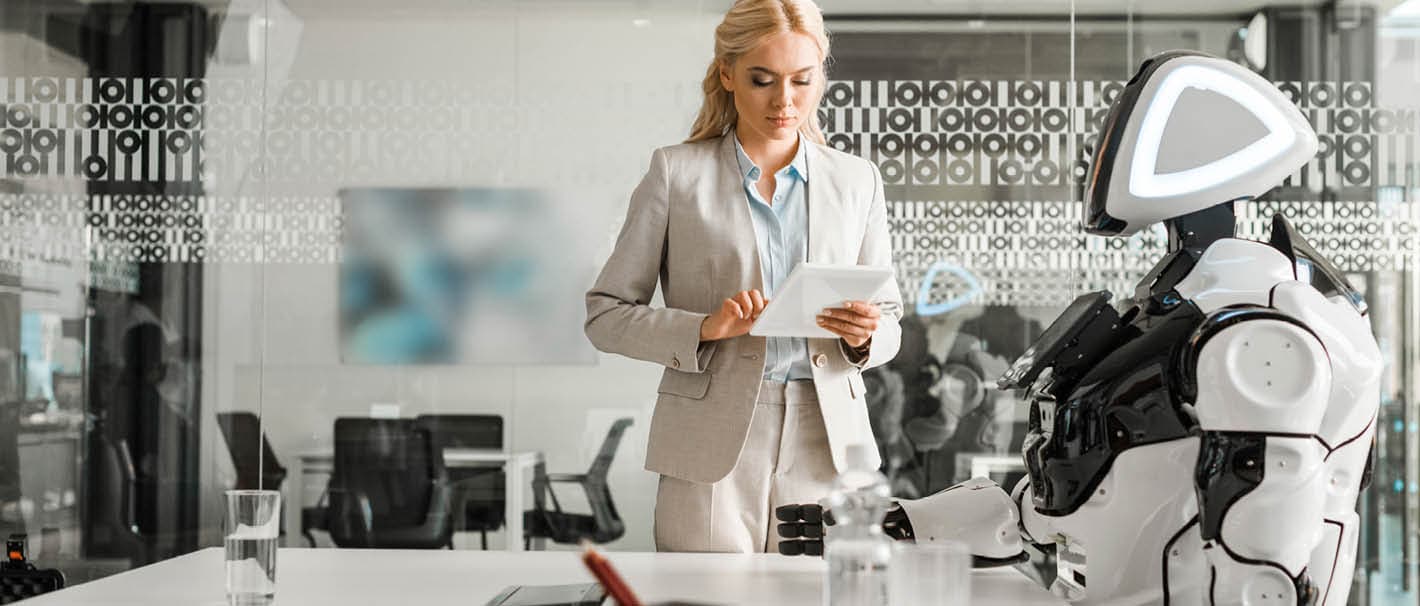 Frau steht mit einem Laptop in einem futuristischen Büro