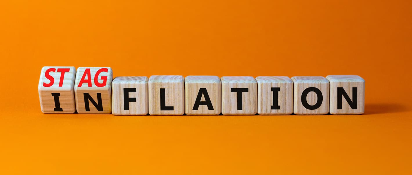 Buchstabenwürfel, die das Wort Inflation bilden und sich gerade zum Wort Stagflation weiterdrehen